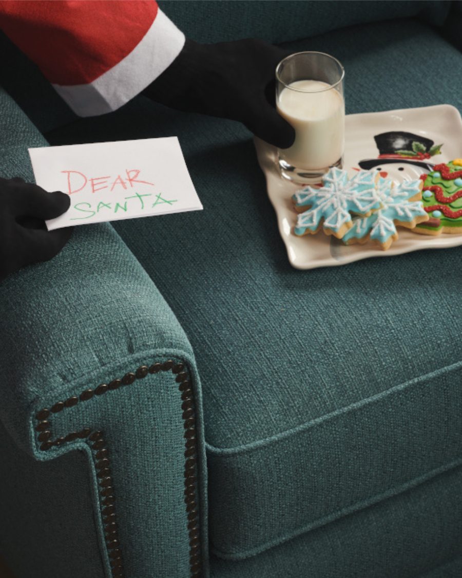 Santa reaching for milk and cookies on a teal iClean fabric sofa