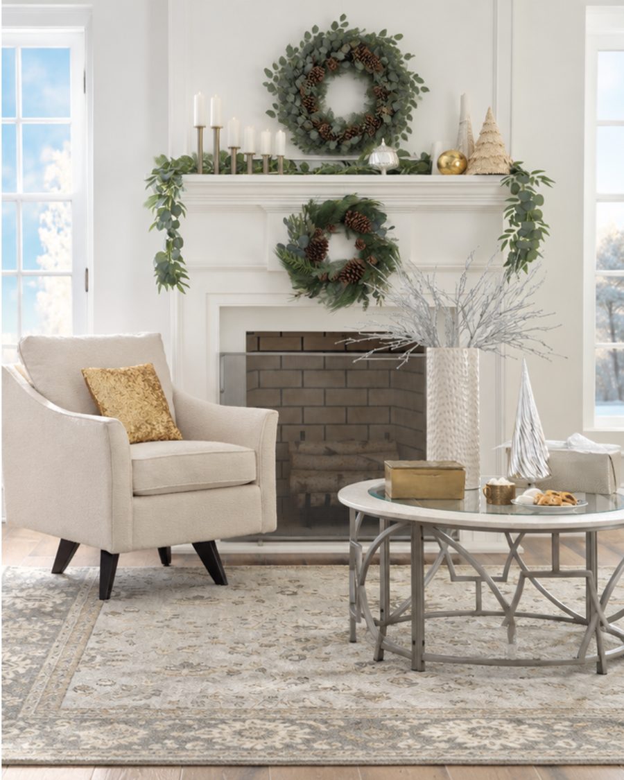 Cream swivel chair with a gold pillow beside a white fireplace with wreaths and garland